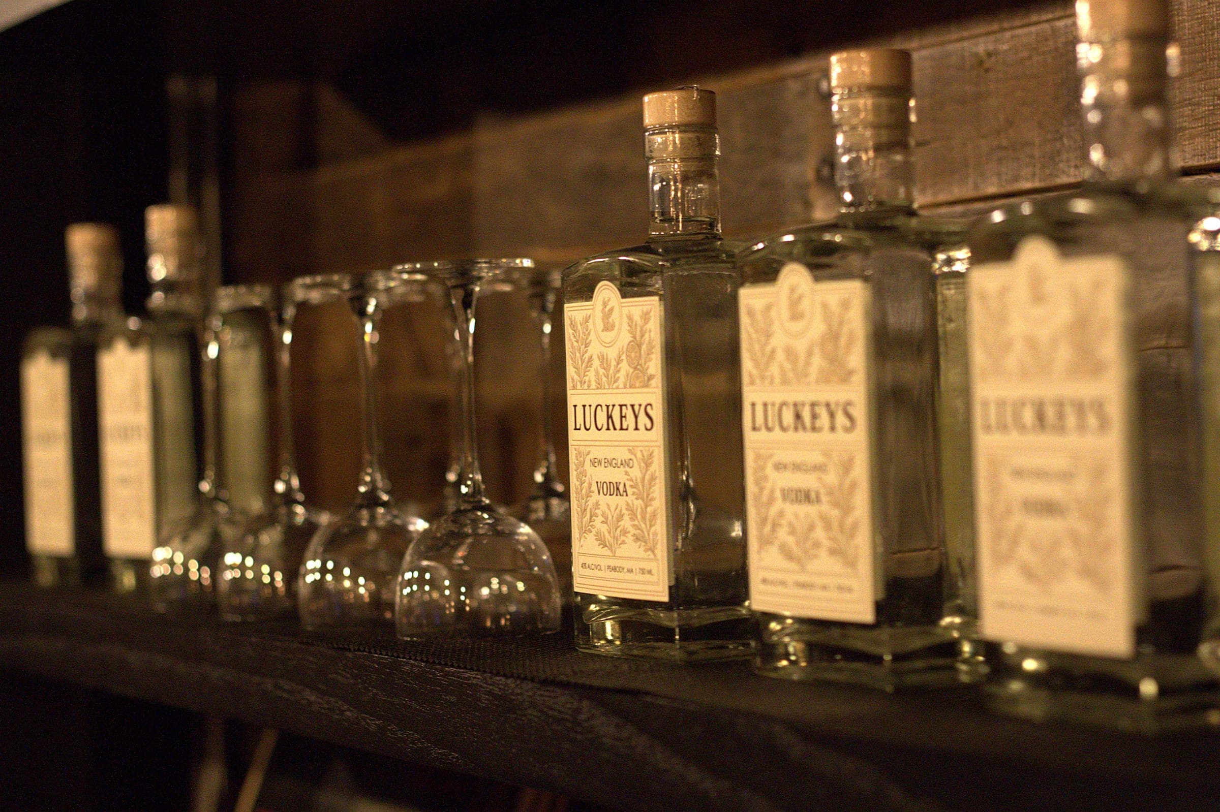 Luckeys New England Vodka bottles and stemware lined along the backbar shelf