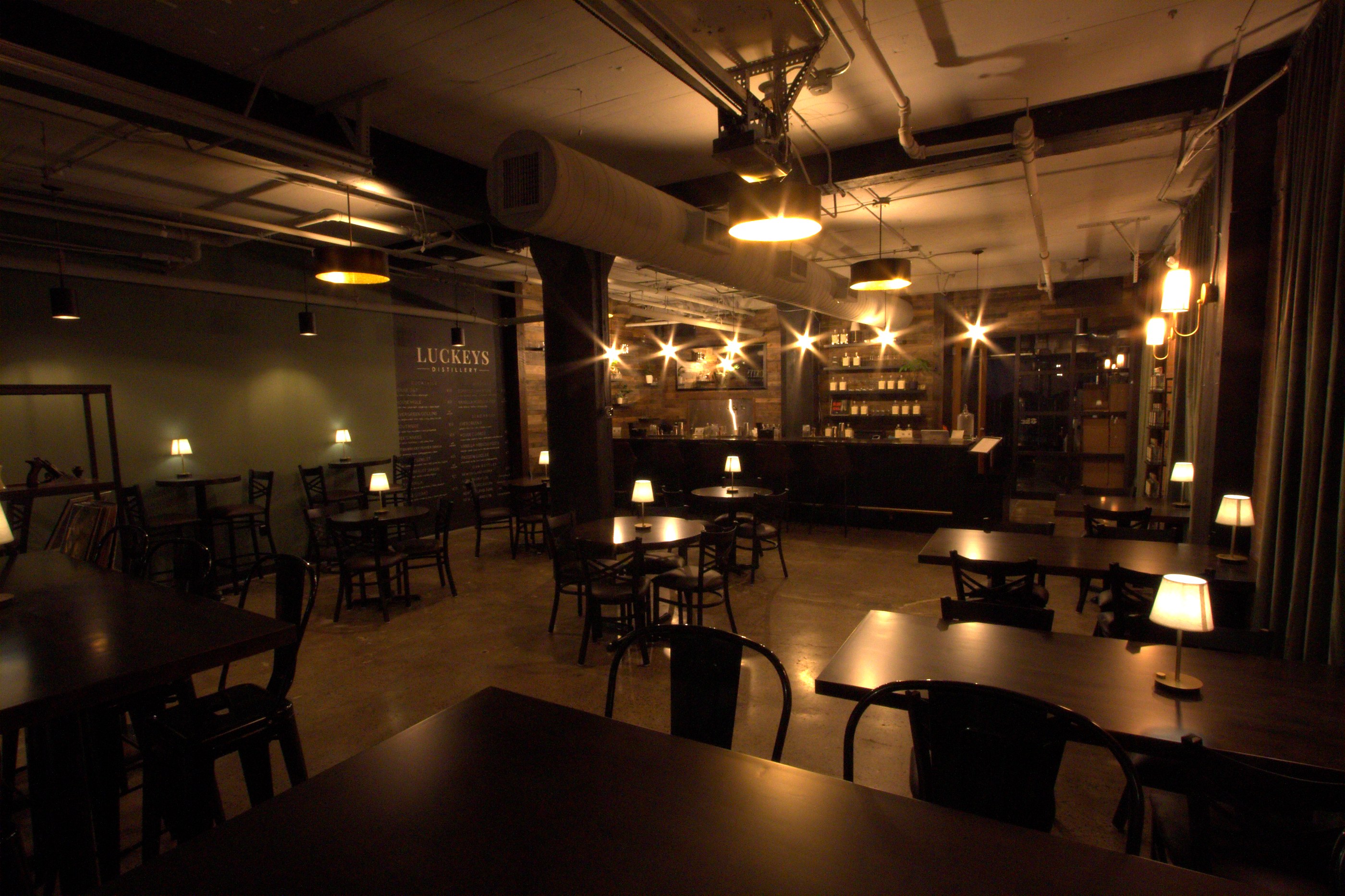 The Luckeys bar room after close — tables and lamps lit, the bar glowing at the back
