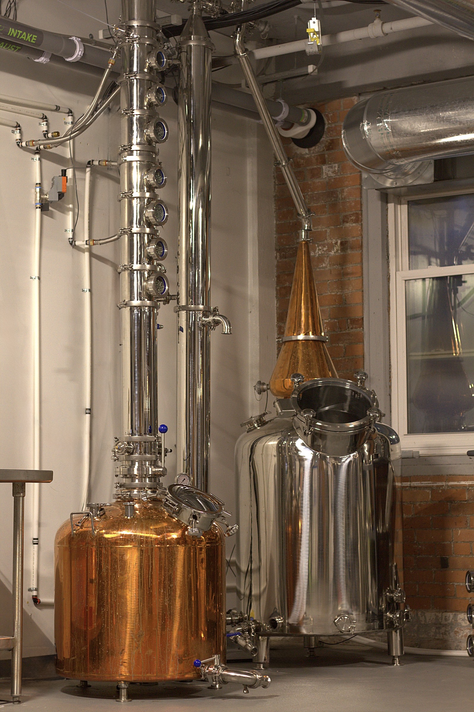 The stills — copper pot, column, and alembic on the distillery floor